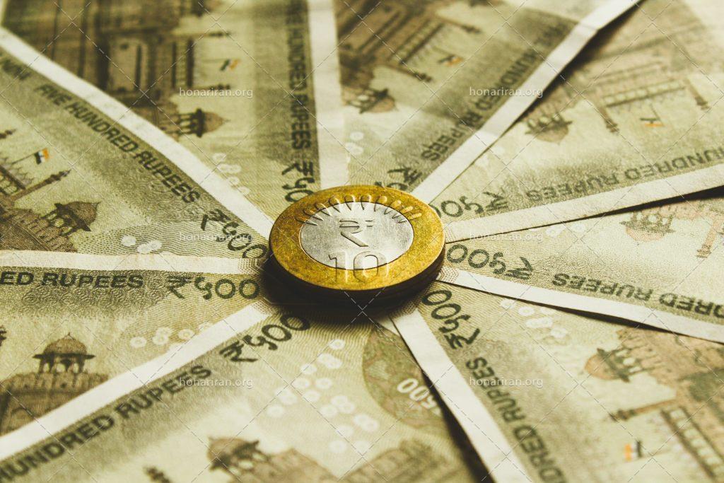 عکس با کیفیت سکه طلایی بر روی پول های کاغذی