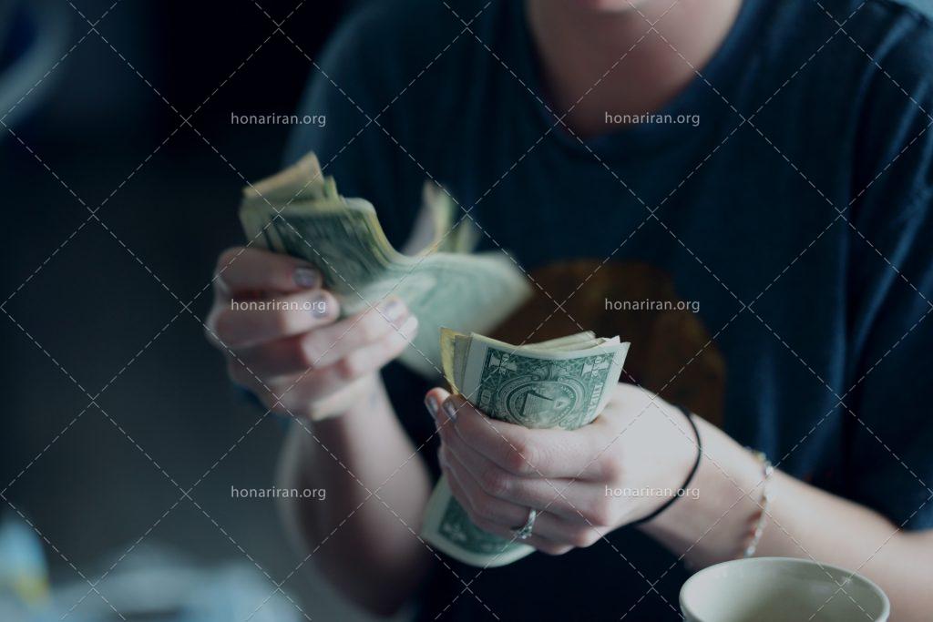 عکس با کیفیت زن در حال شمردن دلار ها