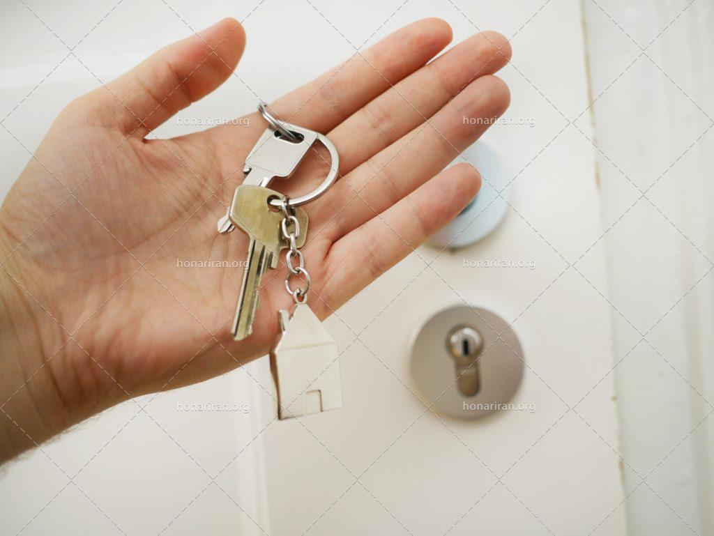 عکس با کیفیت دسته کلید به همراه جاسوییچی خانه در دست