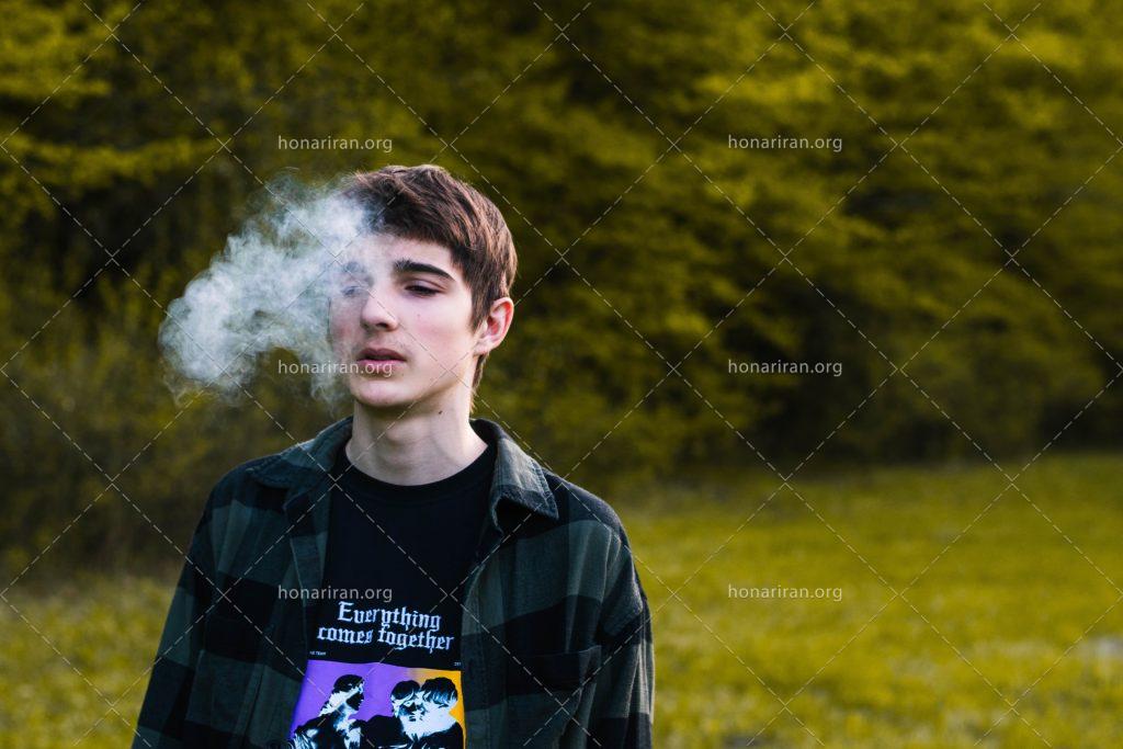 عکس با کیفیت نوجوان در حال کشیدن سیگار