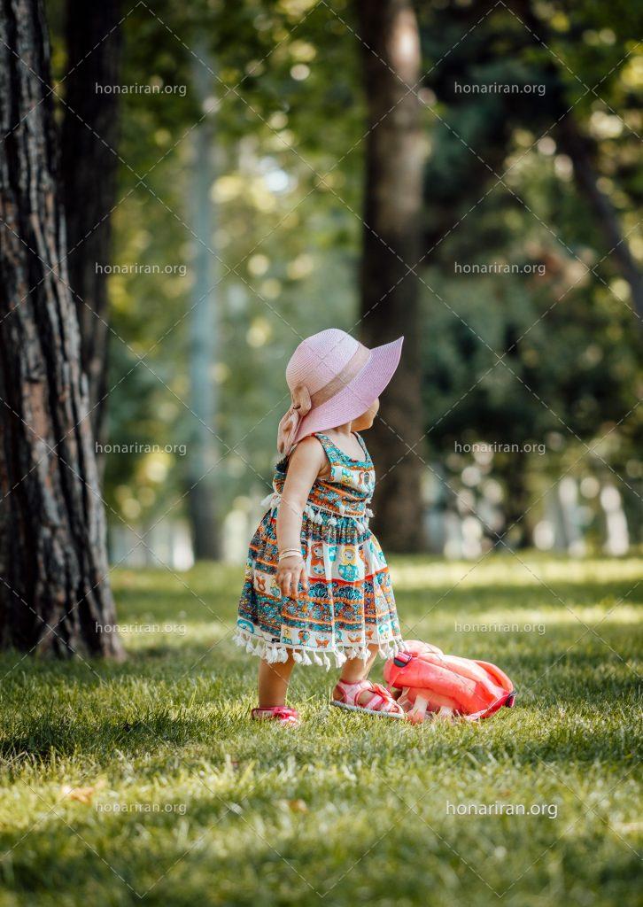 عکس با کیفیت کودک با لباس زیبا و کلاه و کیف قرمز