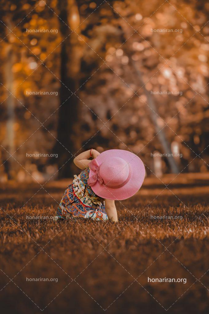عکس با کیفیت دختر بچه با کلاه صورتی رنگ در جنگل