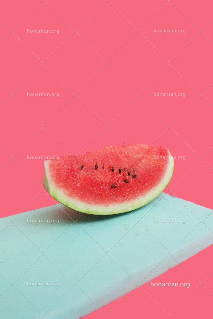 عکس با کیفیت یک برش هندوانه بر روی یونولیت آبی