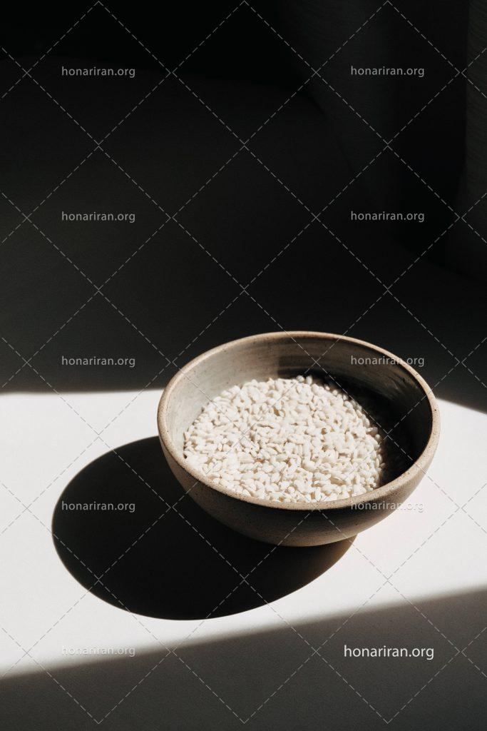 عکس با کیفیت برنج خام داخل پیاله چوبی
