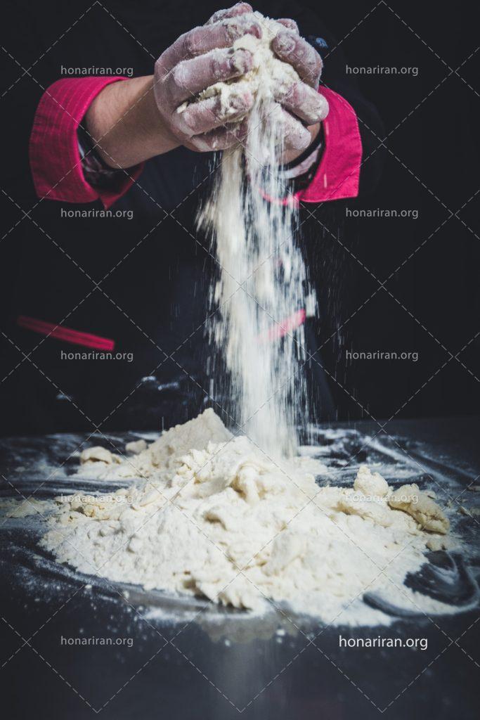 عکس با کیفیت شیرینی پز در حال ورز دادن خمیر