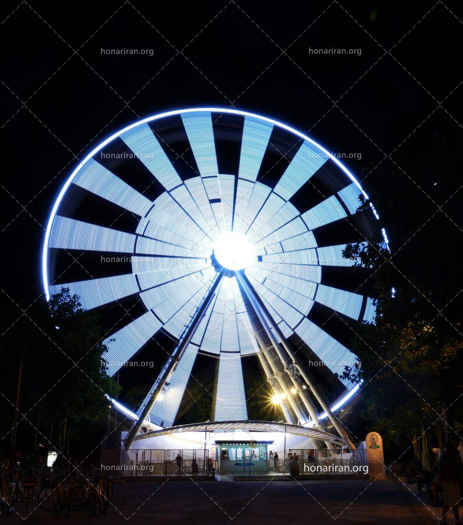عکس با کیفیت چرخ فلک بزرگ در شهر بازی با نور های آبی