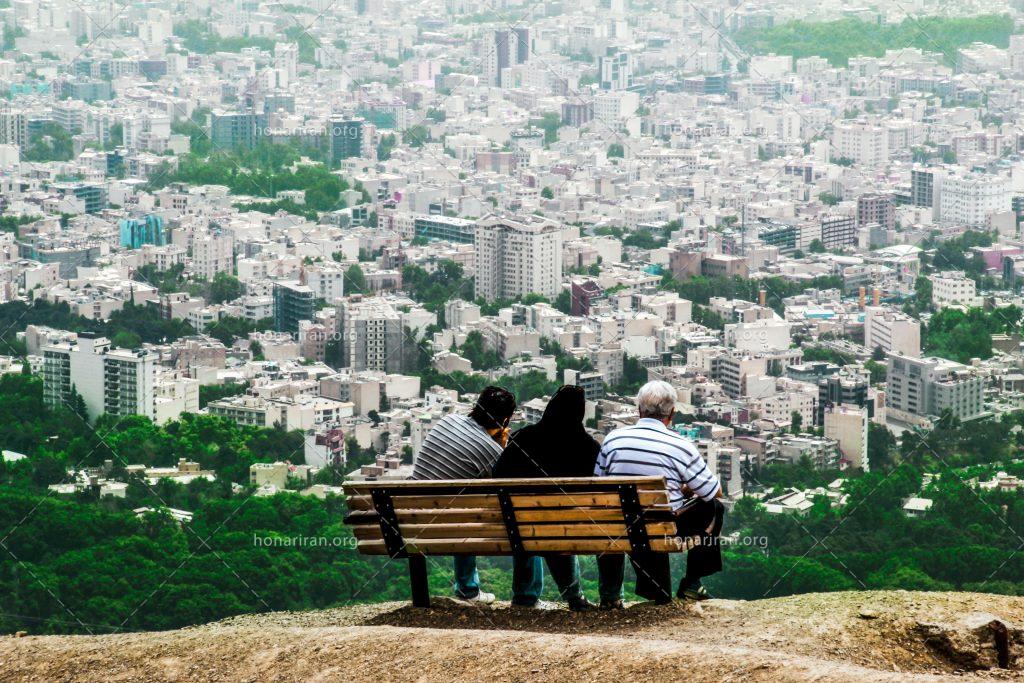 عکس با کیفیت بام تهران و سه خانواده نشسته بر روی صندلی