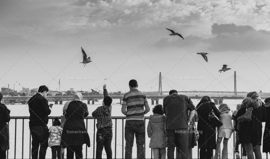عکس با کیفیت مردم ایستاده در کنار دریاچه و پل