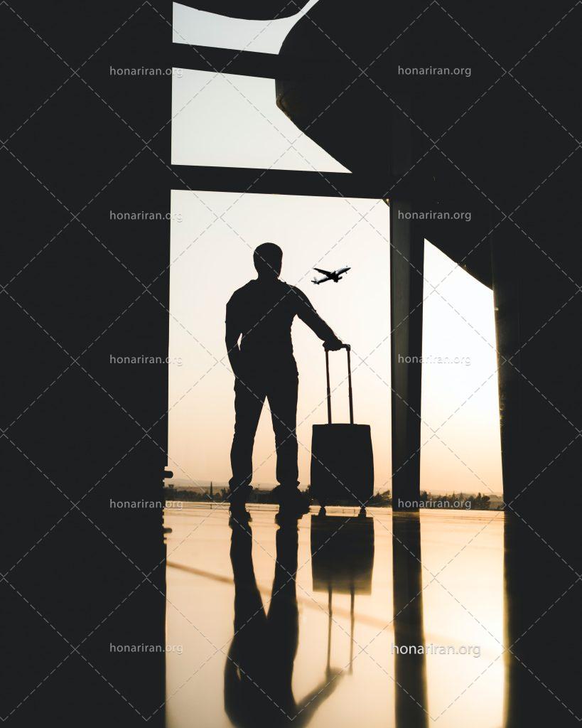 عکس با کیفیت مرد چمدان به دست در حال نگاه کردن هواپیما