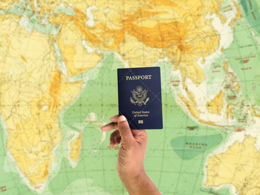 عکس با کیفیت نقشه بزرگ جهان و پاسپورت در دست مرد