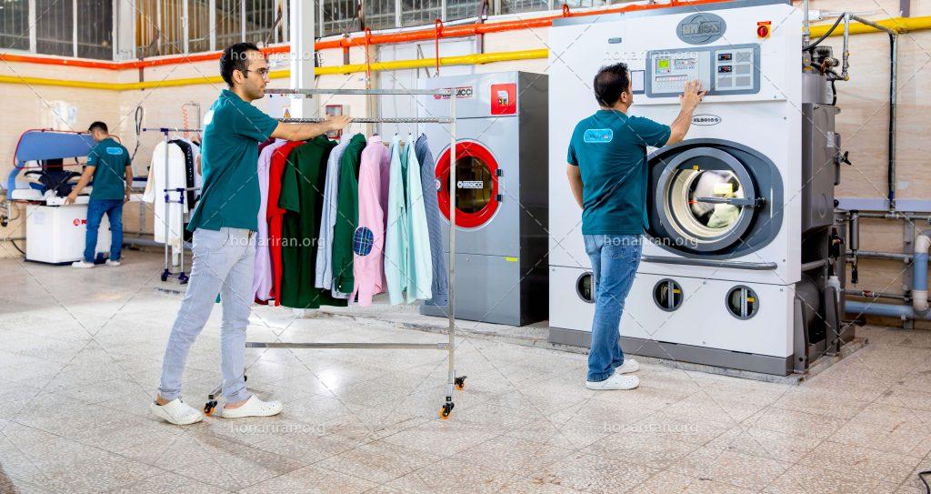 عکس با کیفیت مرد در حال روشن کردن لباسشویی بزرگ