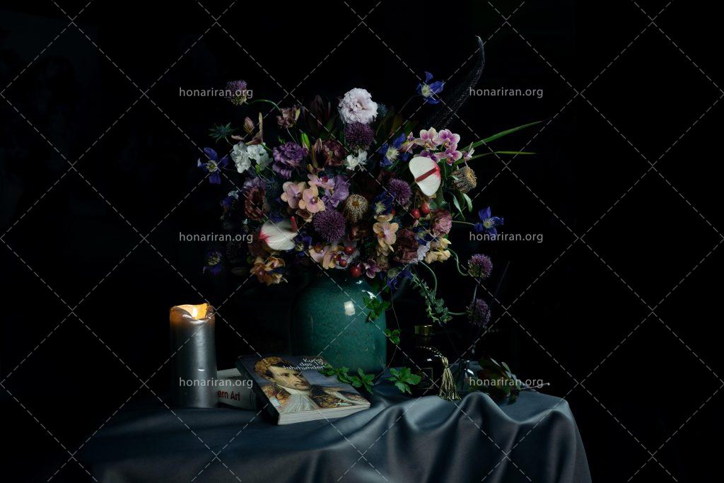 عکس با کیفیت شمع و کتاب در کنار گلدان زیبا پر از گل