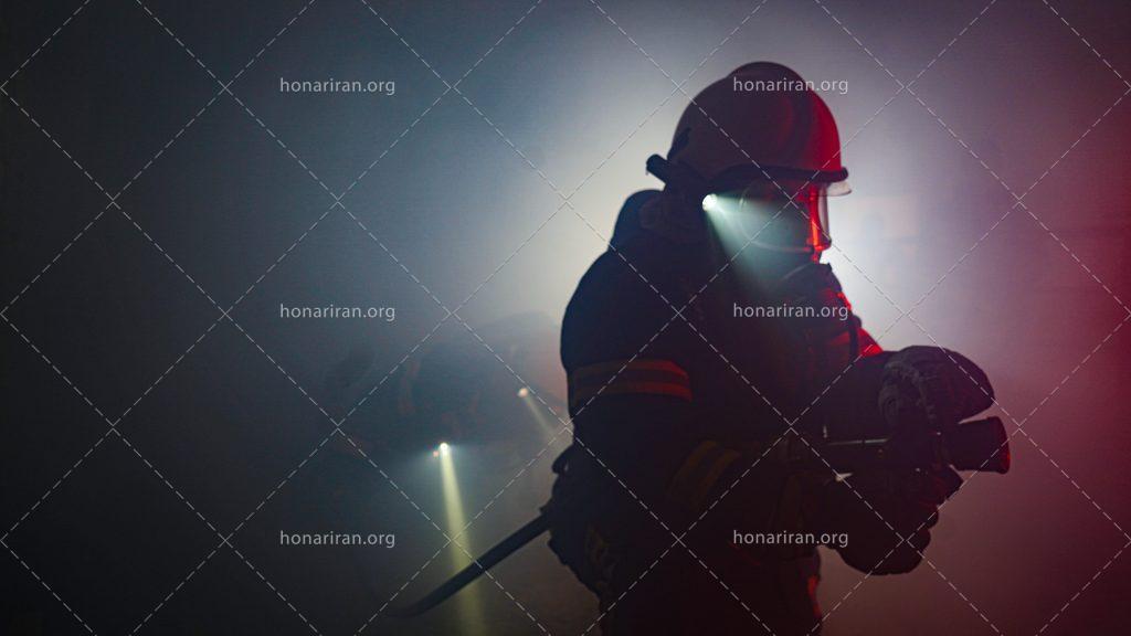 عکس با کیفیت شلنگ در دست آتش نشان به همراه ماسک