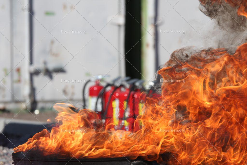 عکس با کیفیت شعله آتش در کنار کپسل آتش نشانی