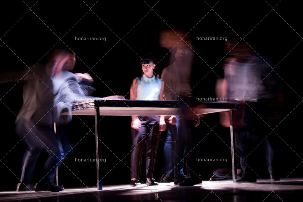 عکس با کیفیت صحنه تئاتر و بازیگران ایستاده پشت میز