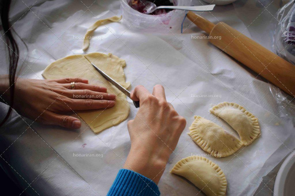 عکس با کیفیت زن در حال دست کردن پیراشکی