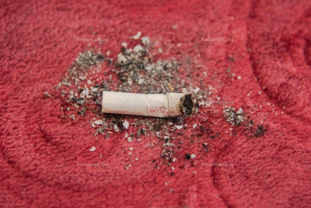 عکس با کیفیت یک ته سیگار بر روی فرش قرمز