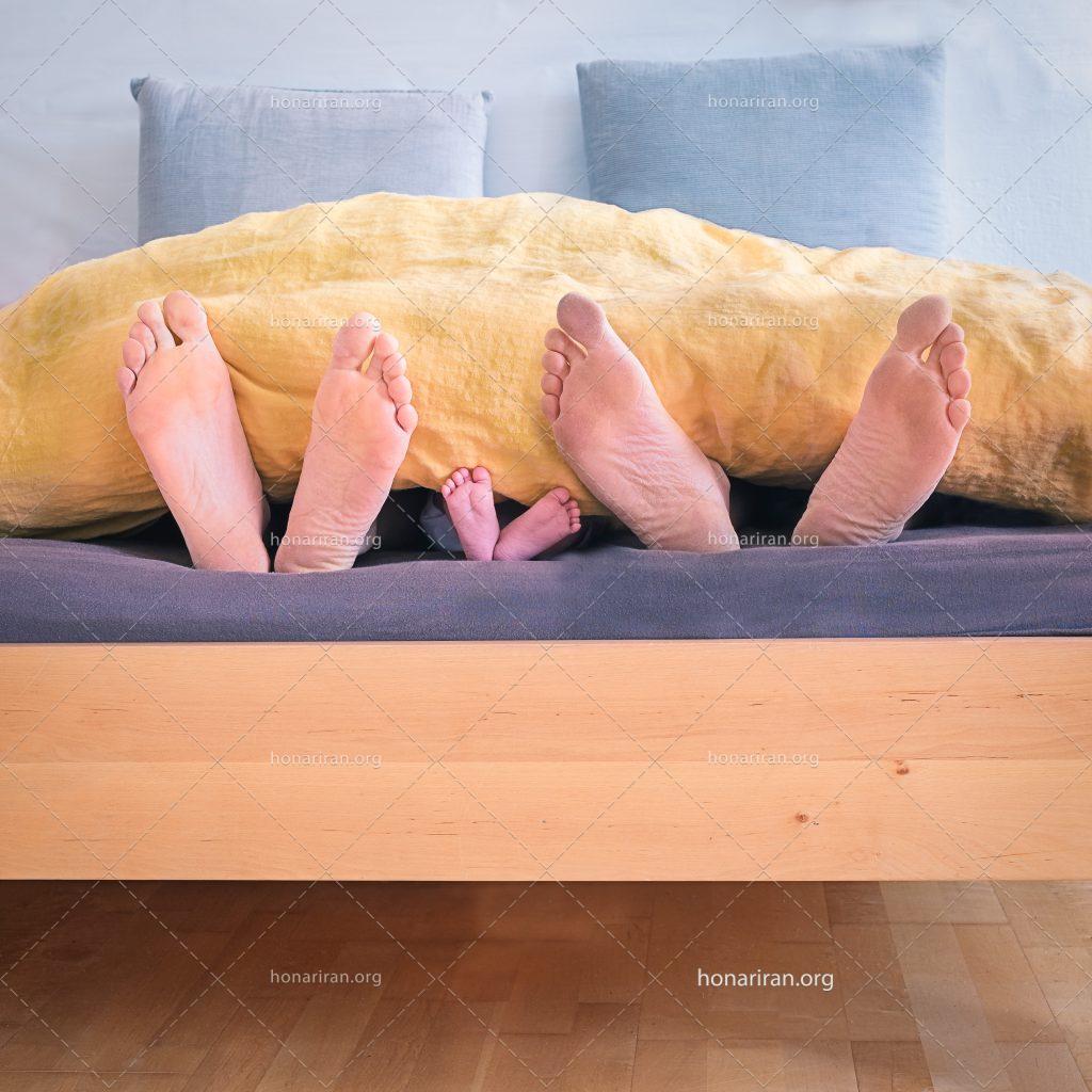 عکس با کیفیت پاهای نوزاد در کنار پاهای پدر و مادر