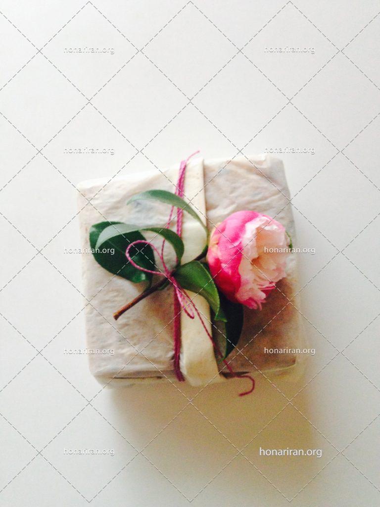 عکس با کیفیت گل کوچک صورتی بر روی جعبه کادو