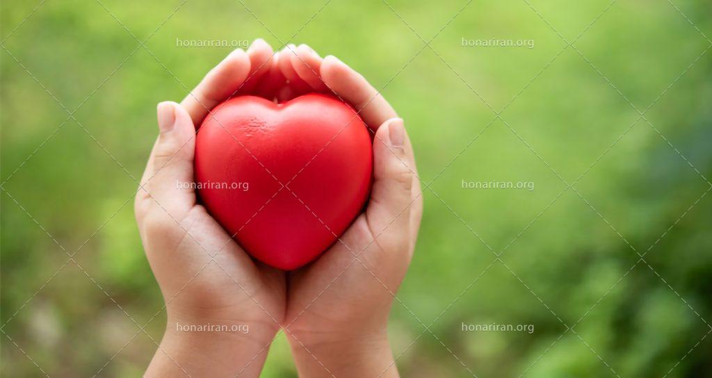 عکس با کیفیت قلب قرمز در دستان زن