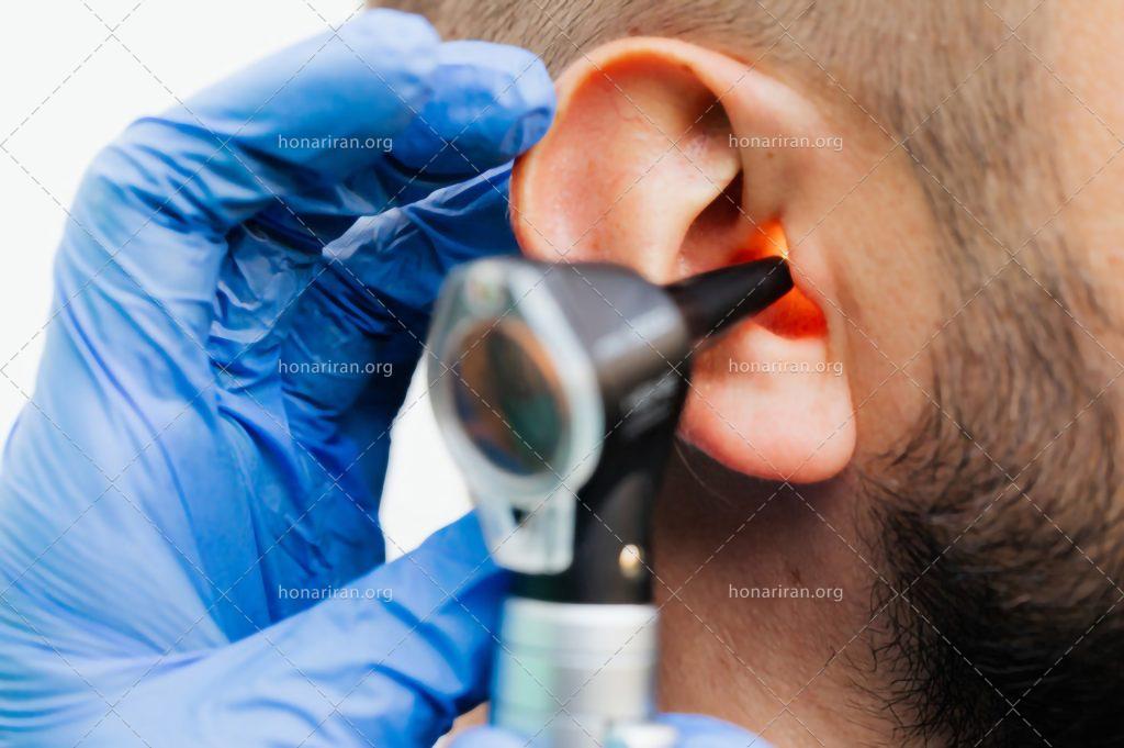 عکس با کیفیت پزشک در حال چک کردن گوش های مرد