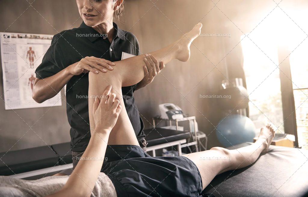 عکس با کیفیت پزشک در حال نرمش دادن پای زن