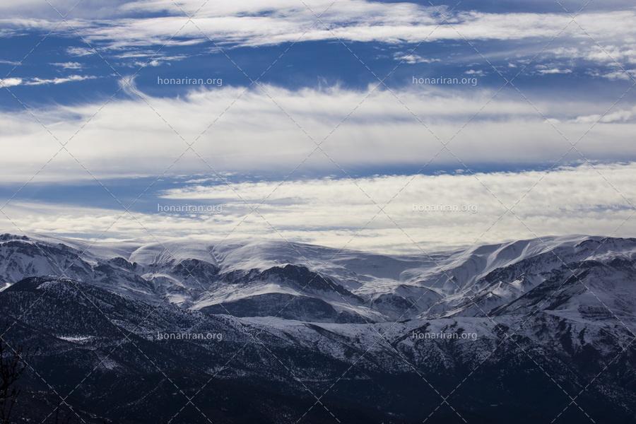 قطعه عکس رشته کوه زیبا در زمستان با ابرهای زیبا